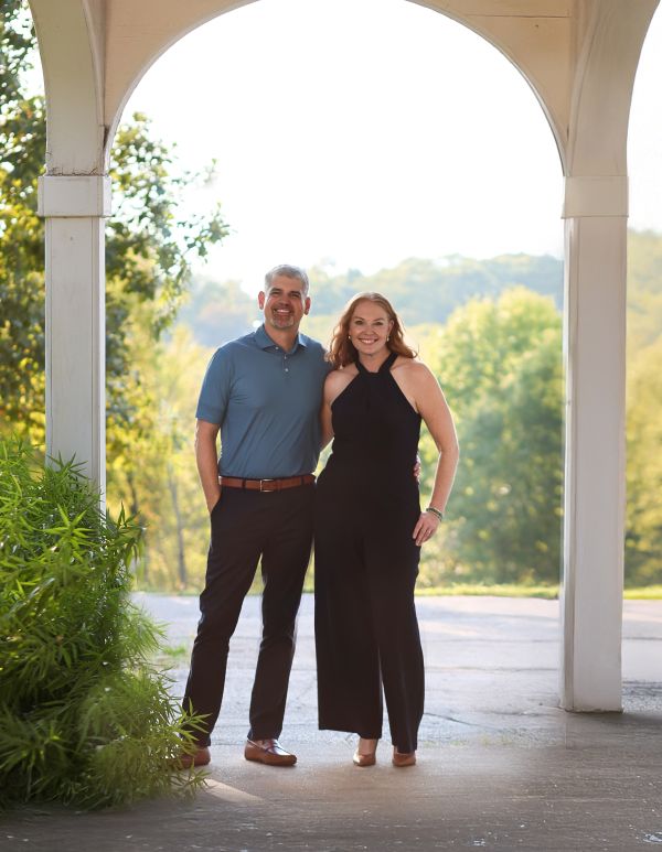 Erik and Kate Morrison, owners of Executive Home Care of Central Saint Louis County standing under an arch